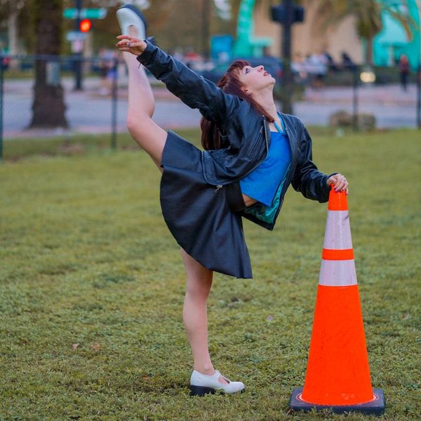 Woman performing a graceful stretching yoga pose outdoors.